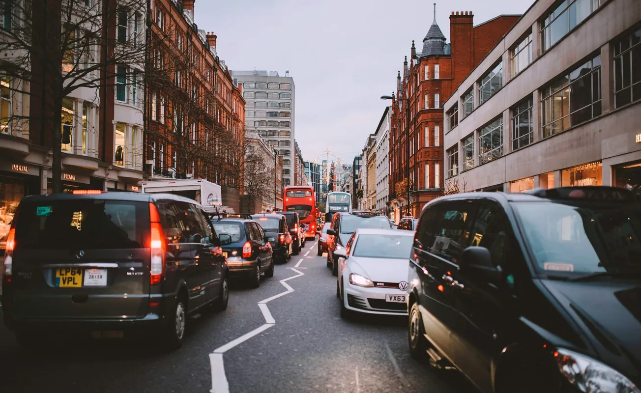 A London street with many cars and taxis in a traffic jam